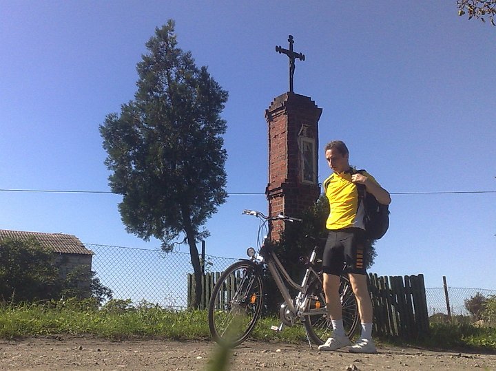 20080831263.jpg - Ostatni sierpniowy weekend. W sobotę byłem jeszcze w Moskwie, ale niedzielę miałem wolną. Szkoda było nie wykorzystać pięknej pogody, więc wsiadłem na rower, aby lasem przejechać do Biedruska, potem mostem nad Wartą do Bolechowa, i jeszcze gdzieś kawałek dalej, ile sił wystarczy. Lubię takie wycieczki, bo po drodze można zobaczyć wiele urokliwych rzeczy - jak choćby taką kapliczkę, jak ta na zdjęciu [zdjęcie zrobione samowyzwalaczem]